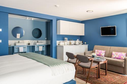 1 dormitorio con paredes azules, 1 cama y 1 sofá en Villa Camélia Boutique House, en Camacha