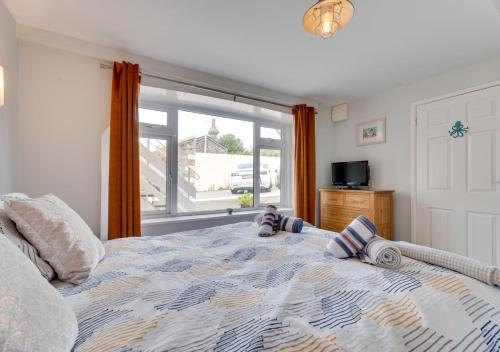 a bedroom with a large bed with a window at Pebbles Marazion in Marazion