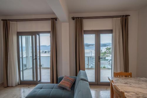a living room with a blue couch and sliding glass doors at Ilya Apart 1 in Bodrum City