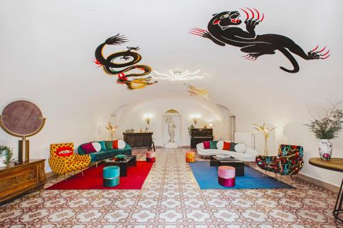 サン・ピエトロ・イン・カリアーノにあるLudwig Houseのリビングルーム(カラフルな家具付)と壁に怪物が飾られています。