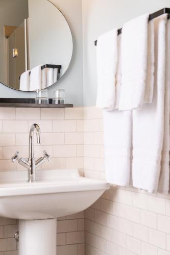a white bathroom with a sink and a mirror at Hótel Blönduós in Blönduós