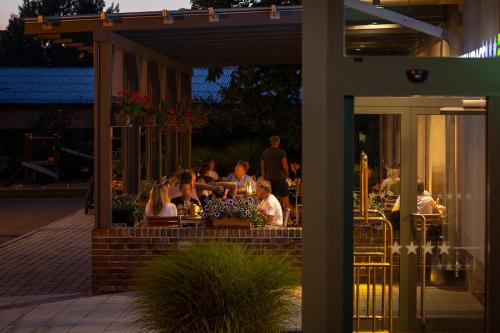 a group of people sitting at a restaurant at night at Wellness Hotel ABÁCIE in Nový Jičín