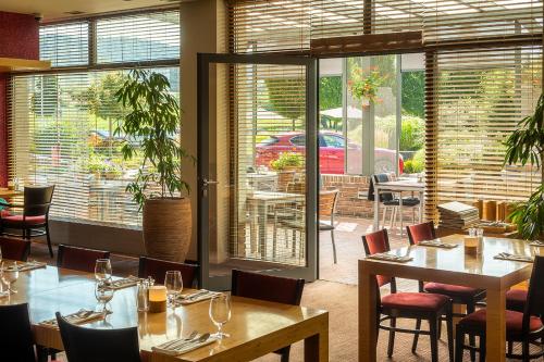 restauracja ze stołami i krzesłami oraz patio w obiekcie Wellness Hotel ABÁCIE w Nowym Jiczynie