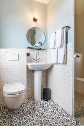a bathroom with a sink and a toilet and a mirror at Hótel Blönduós in Blönduós