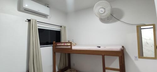 a room with a desk with a fan and a window at Space Hostel , quartos privativos in Arraial do Cabo
