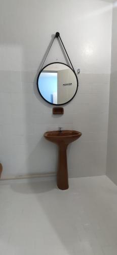 a mirror hanging on a wall next to a table at Space Hostel , quartos privativos in Arraial do Cabo