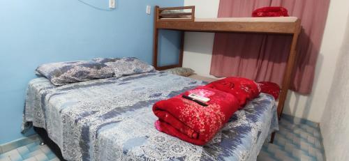 a bedroom with a bed with a red bag on it at Space Hostel , quartos privativos in Arraial do Cabo