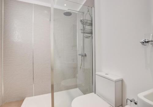 a bathroom with a shower with a toilet and a sink at The Lookout - Sennen in Sennen