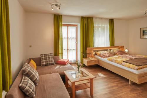 uma sala de estar com uma cama e um sofá em Brauereigasthof Zur Post em Eschlkam