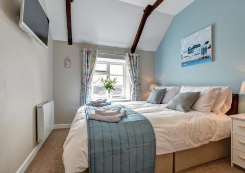 a bedroom with a large bed with a blue wall at Otterbridge in Saint Breward