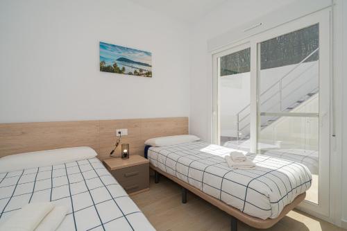 due letti in una stanza con finestra di Bonita a Avileses