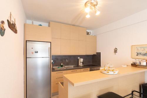 a kitchen with a stainless steel refrigerator and wooden cabinets at Houseloft Grand Sunset Siviri Beach in Siviri