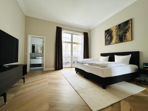 een grote slaapkamer met een bed en een televisie bij Luxury Home / 3-Raum-Suite an der Frauenkirche / 2 in Dresden
