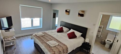 1 dormitorio con 1 cama grande con almohadas rojas en Fal Mor House, en Belmullet