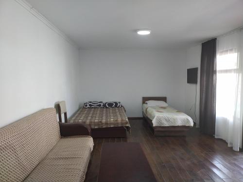 a living room with a couch and a bed at Пансионат Сабрина in Bosteri