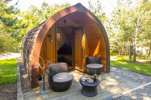 una pequeña casa circular con dos taburetes y una mesa en Loch Lomond Luxury Lodges, en Drymen