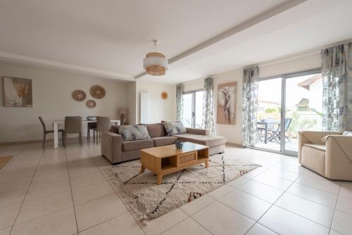 a living room with a couch and a table at Les Résidences première ligne in Andernos-les-Bains