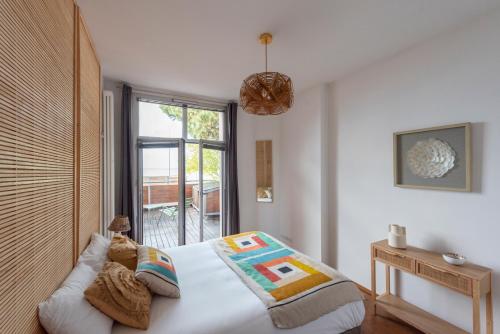 sypialnia z łóżkiem i dużym oknem w obiekcie Les Résidences première ligne w mieście Andernos-les-Bains