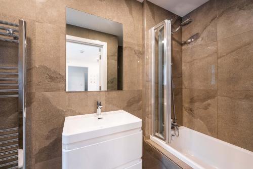 a bathroom with a sink and a shower and a mirror at The Farringdon in London