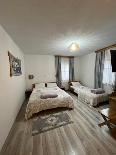 a bedroom with two beds in a room with wooden floors at Rustic Inn River 2 in Plitvička Jezera