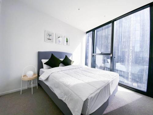 een slaapkamer met een groot bed en een groot raam bij Glamorous Southbank home#MSQ1410 in Melbourne
