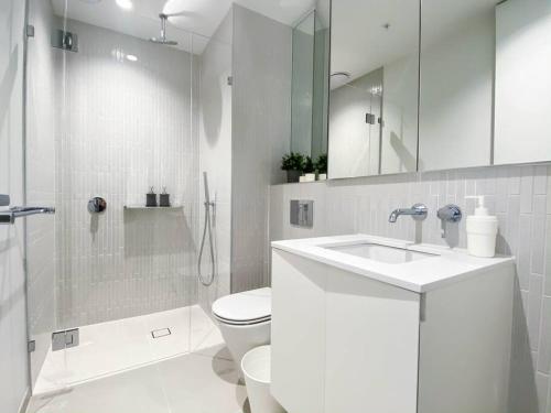 een witte badkamer met een toilet en een wastafel bij Glamorous Southbank home#MSQ1410 in Melbourne