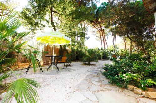 a patio with a table and a yellow umbrella at La Villetta in Pula