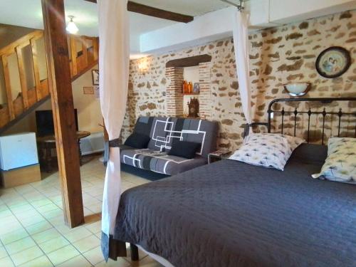 a bedroom with a bed and a couch in a room at Chambres d'hôtes Châtres-Sur-Cher in Châtres-sur-Cher