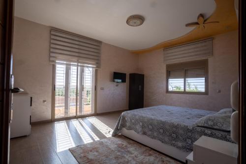 een slaapkamer met een bed en een groot raam bij Lux Villa, Pool And Mountains View in Ourika