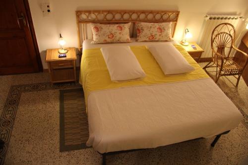 Un dormitorio con una cama grande con sábanas y almohadas amarillas. en Burchiello b&b, en Florencia