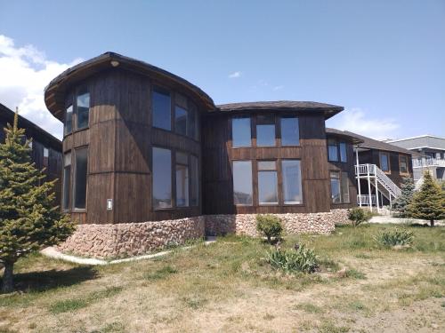 a large wooden house with windows on a yard at Пансионат Сабрина in Bosteri