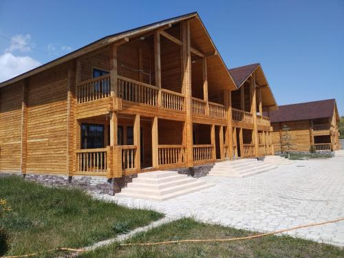a large log home with a large deck at Пансионат Сабрина in Bosteri