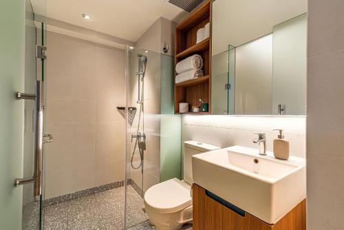 a bathroom with a toilet and a sink and a shower at Weave Suites - Midtown in Singapore