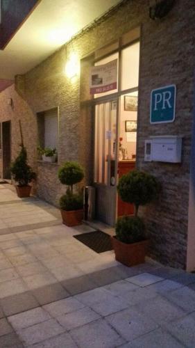 a building with three potted plants in front of it at Pensión NAVIA A Pontenova in A Pontenova