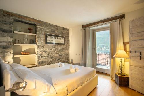 1 dormitorio con cama grande y ventana grande en Ca Sbrisiga in Moltrasio, en Moltrasio