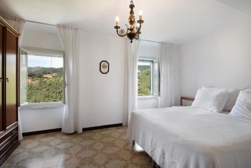 a white bedroom with a bed and a window at Casa Luci in Levanto