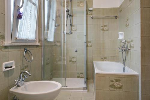 a bathroom with a shower and a sink and a tub at Casa Luci in Levanto
