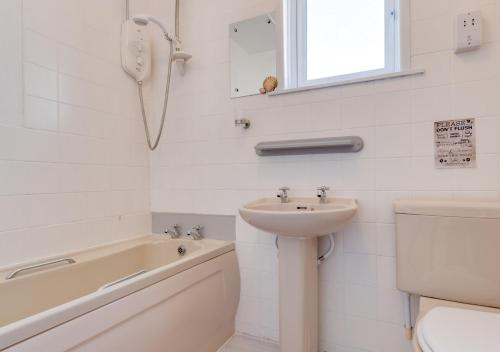 a bathroom with a sink and a toilet and a bath tub at Coverack Cottage in Saint Keverne