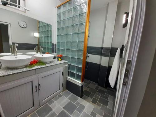 a bathroom with two sinks and a shower at Cosy Villa in Pointe aux Piments with Shared Pool. in Pointe aux Piments
