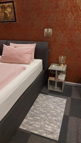 a bedroom with a bed with a nightstand next to it at Am Hallenbad Hotel garni in Ratingen