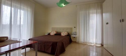 ein Schlafzimmer mit einem Bett und einer grünen Decke in der Unterkunft Il Casale Le Tre Volte in Solfara Mare