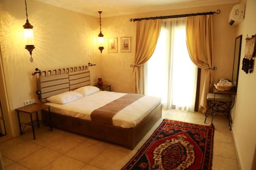ein Schlafzimmer mit einem Bett und einem großen Fenster in der Unterkunft Dardanos Hotel in Patara
