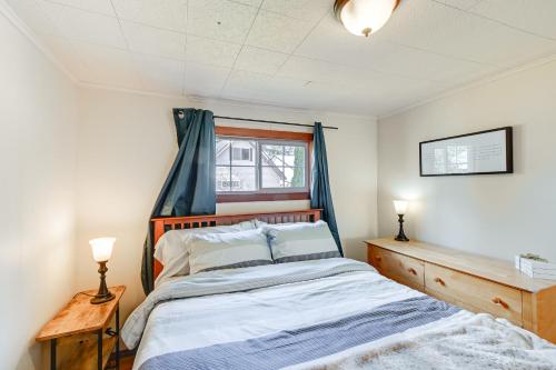 Schlafzimmer mit einem Bett mit einem Kopfteil aus Holz und einem Fenster in der Unterkunft Rustic Allyn Cabin Private Isl Community with Kayak in Allyn