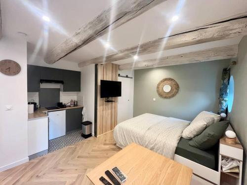une chambre avec un lit et une table et une cuisine dans l'établissement Cocon cosy au cœur du vieux Port, à Marseille