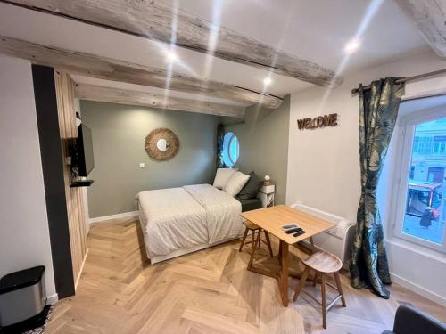 une chambre avec un lit, une table et une fenêtre dans l'établissement Cocon cosy au cœur du vieux Port, à Marseille