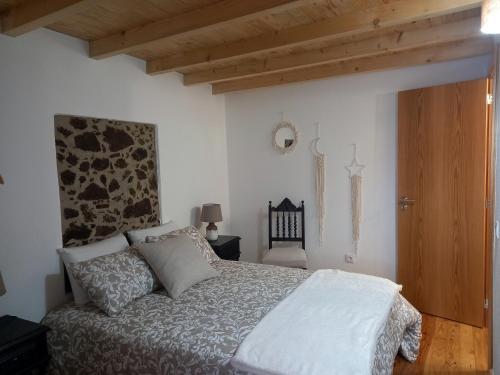 una camera da letto con un letto e un soffitto in legno di Amieira do Tejo guest house a Barca da Amieira