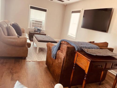 a living room with a couch and a flat screen tv at Farm Charm 