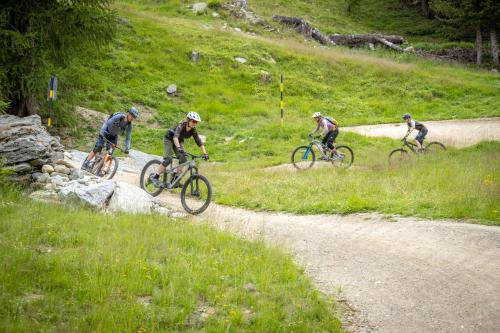 a group of people riding bikes down a dirt road at Aktiv Hotel & Spa Hannigalp in Grächen