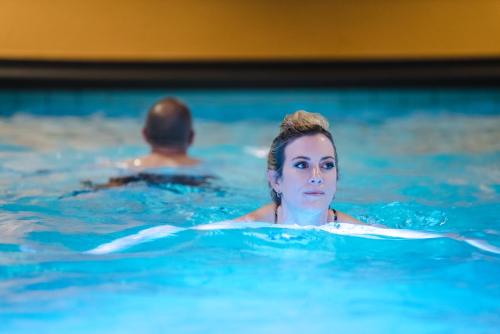 Eine Frau, die im Schwimmbad schwimmt. in der Unterkunft Aktiv Hotel & Spa Hannigalp in Grächen