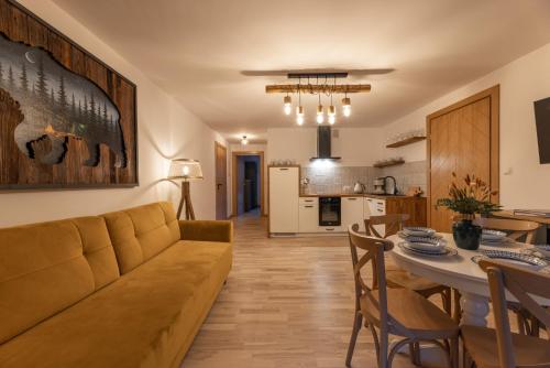 a living room and kitchen with a couch and a table at Anielski Zakątek Solina - balia z jacuzzi i sauna w cenie pobytu in Solina
